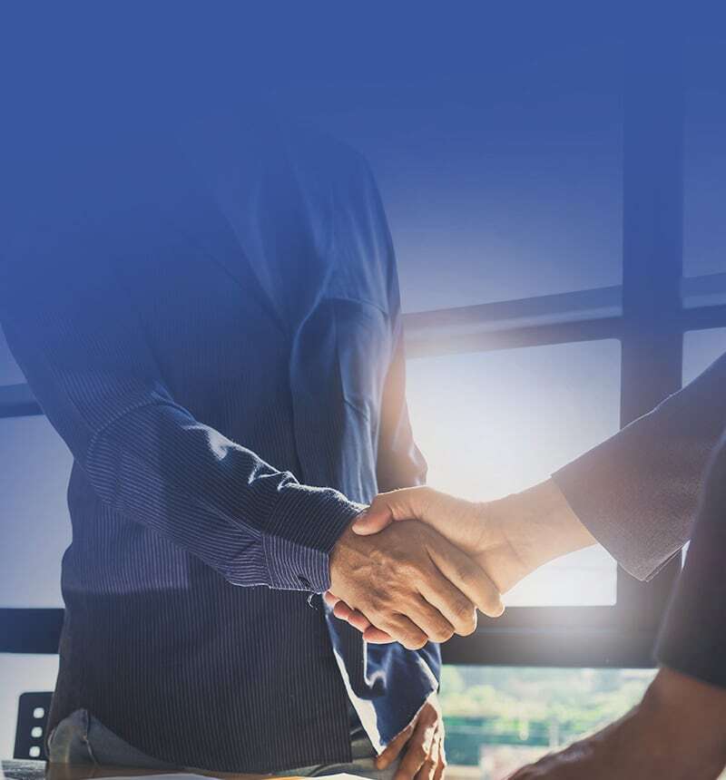two people shaking hands over a desk