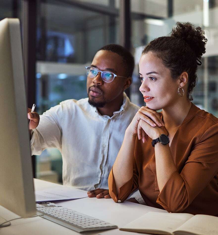 Two adults looking at a computer monitor